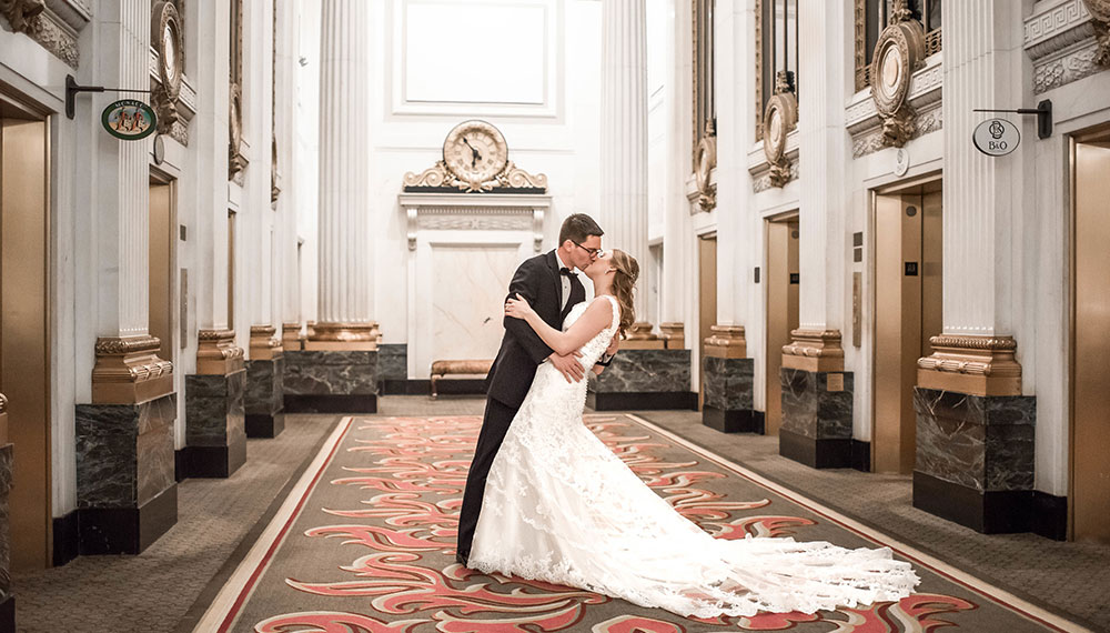 Bride and groom kiss in front elevators at Hotel Monaco Baltimore